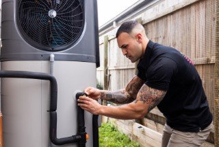 Plumber servicing a heat pump hot water system